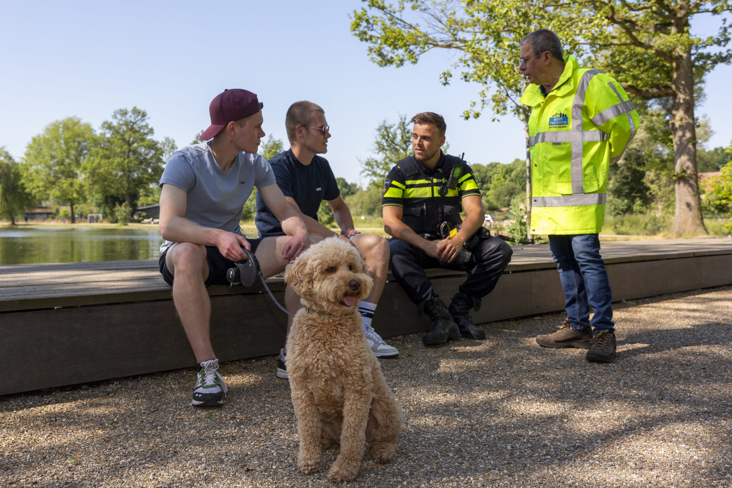 Politie en buurtpreventie met jongens en hond