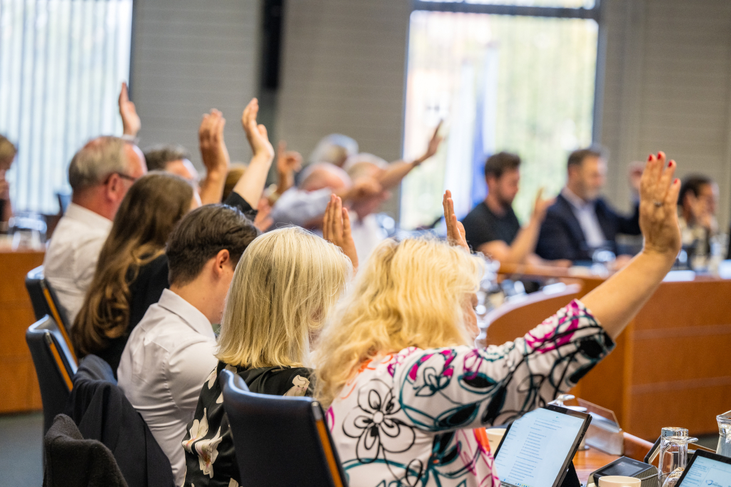 Mensen die stemmen in de raadzaal
