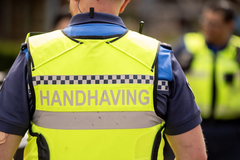 Afbeelding rugzijde geel hesje handhaver